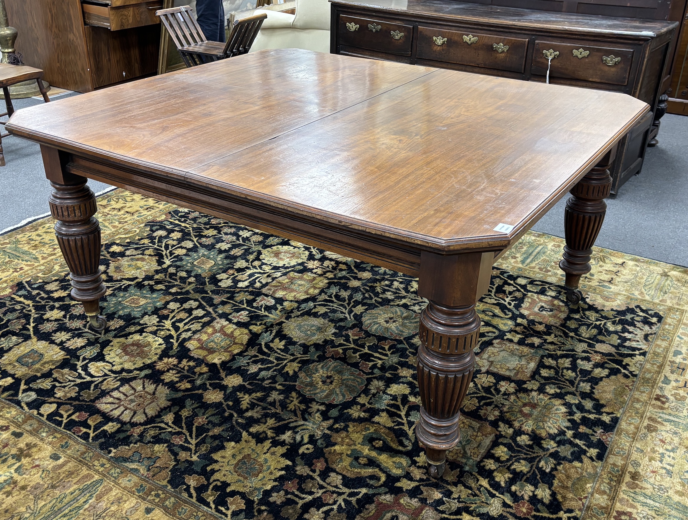 A late Victorian walnut extending dining table, on turned fluted baluster legs, 240cm extended, two spare leaves, depth 137cm, height 73cm